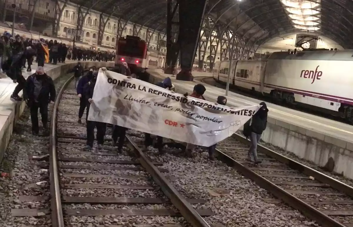 Diverses persones tallen les vies del tren a l'Estació de França de Barcelona.