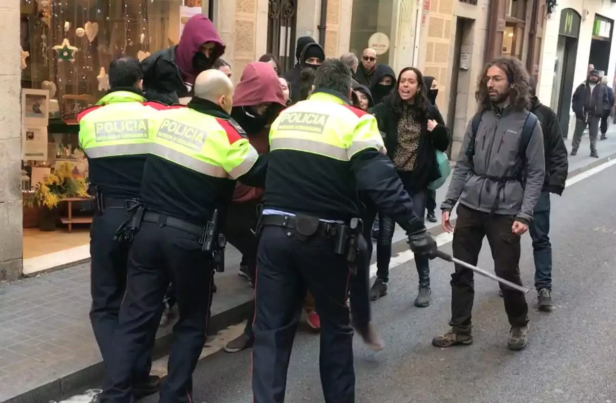 Agents dels Mossos fent fora del carrer un grup d'okupes de Ca La Trava, a Barcelona.