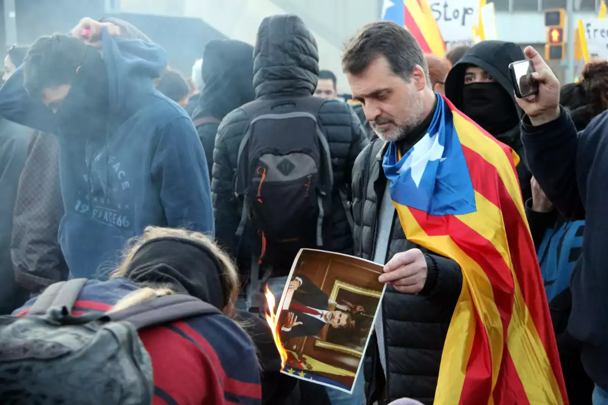 Manifestant cremant una foto del Rei
