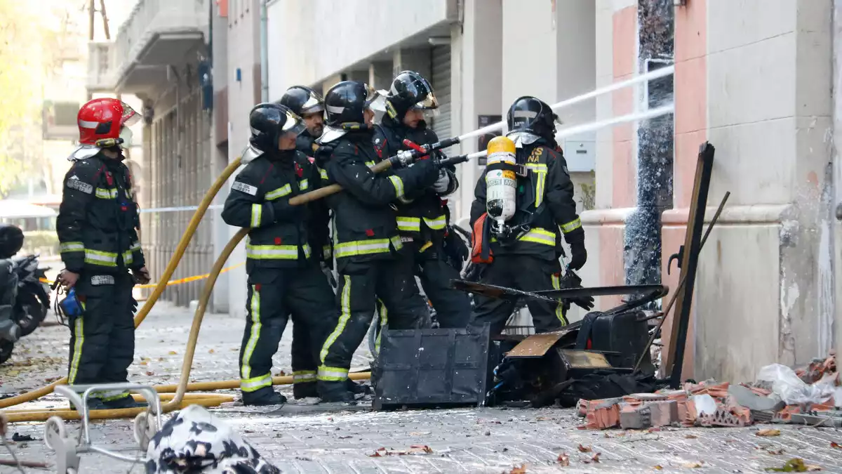 Bombers treballant en l'edifici que ha cremat al carrer Enamorats de Barcelona el 19 de desembre