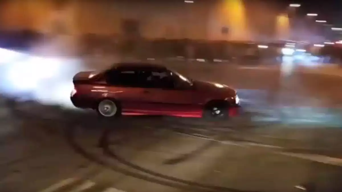 Cotxe vermell derrapant durant una cursa il·legal a Sabadell
