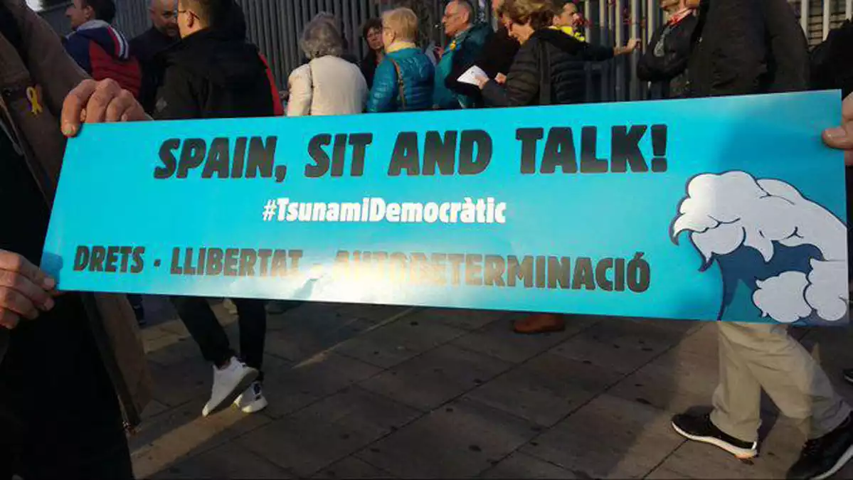 Pancarta amb el lema 'Spain, sit and talk!' de Tsunami Democràtic