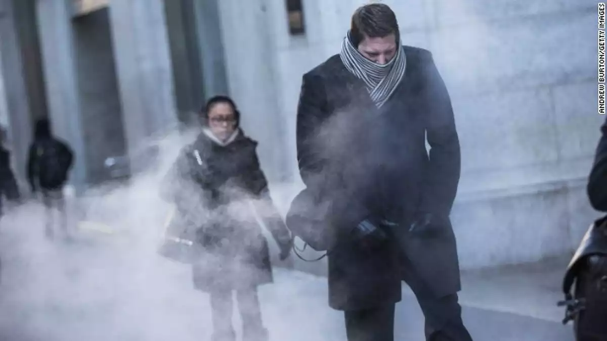 Imatge d'unes persones caminant per un carrer un dia de fred de ple hivern