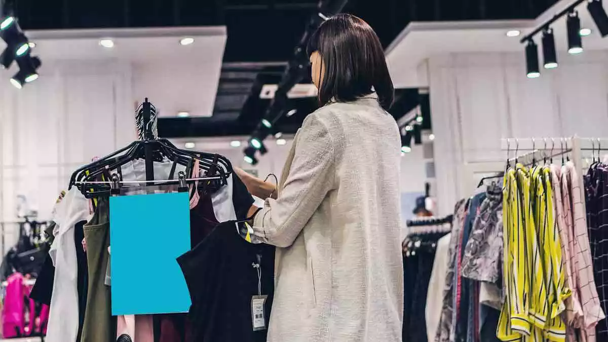 Dona mirant peces de roba en una botiga