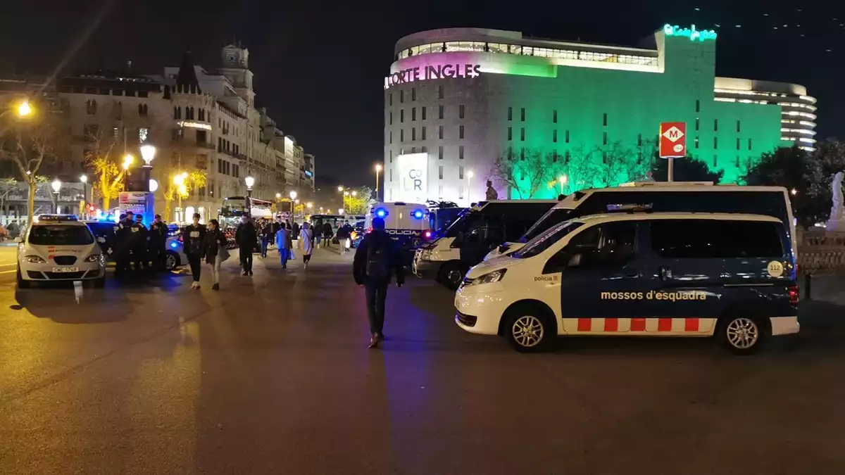 Diverses persones i vehicles dels Mossos d'Esquadra a la plaça de Catalunya de Barcelona el 13 de febrer de 2020