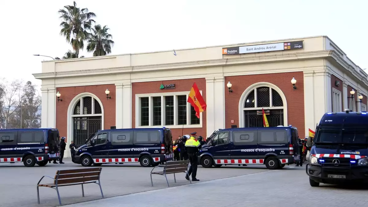 Manifestants amb banderes espanyoles, davant d'un cordó dels Mossos d'Esquadra, a l'estació de tren de Sant Andreu Arenal el 16 de febrer de 2020.