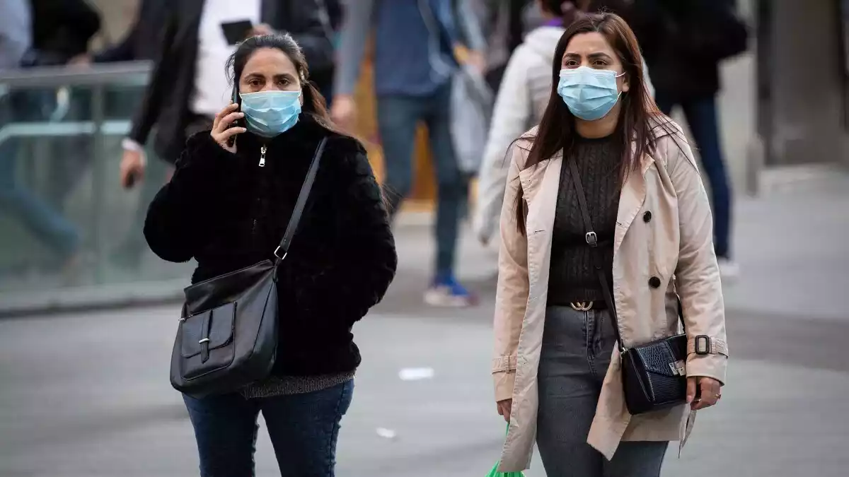 Dues dones amb mascaretes caminant pel centre de Barcelona el 25 de febrer del 2020