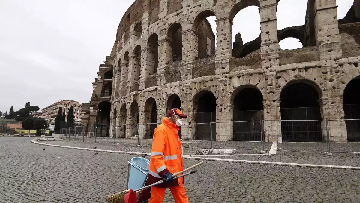 Un operari de neteja pels carrer buits de Roma al carrer del colisseu