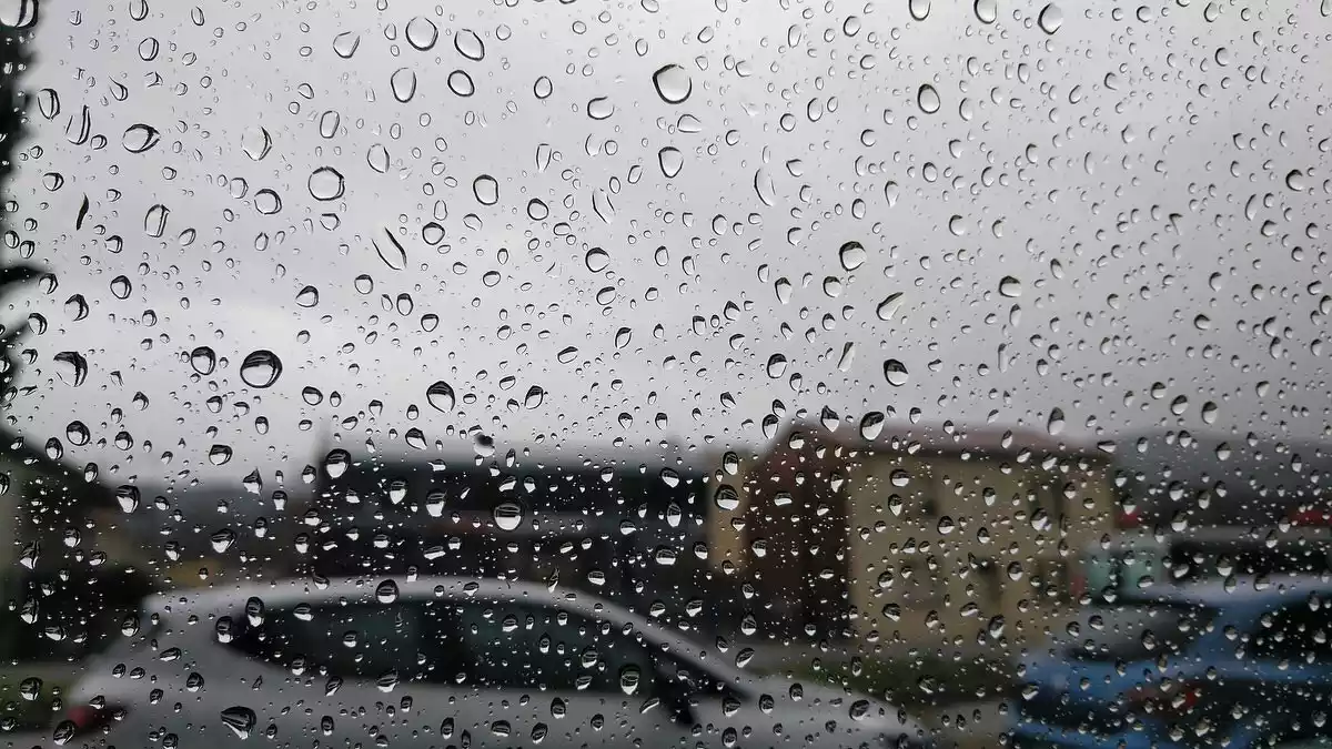 Imatge d'una finestra plena de gotes d'aigua de la pluja