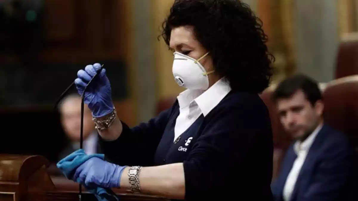 Valentina, treballadora de la neteja del Congrés, desinfectant el faristol el 18 de març de 2020.