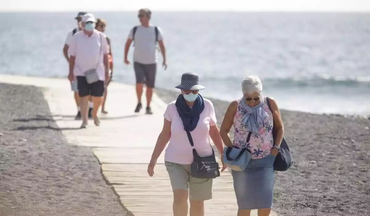 Turistes passejant per les platges d'Adeje (Tenerife) i amb mascaretes el 28 de febrer del 2020