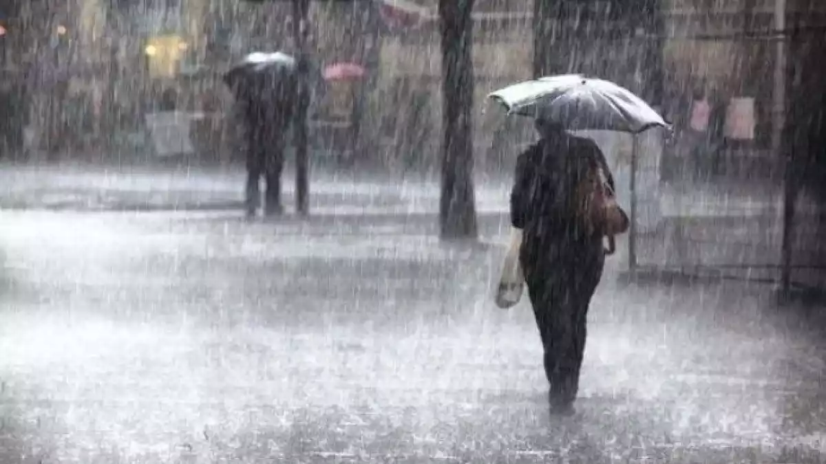 Imatge d'una dona passejant sota la pluja