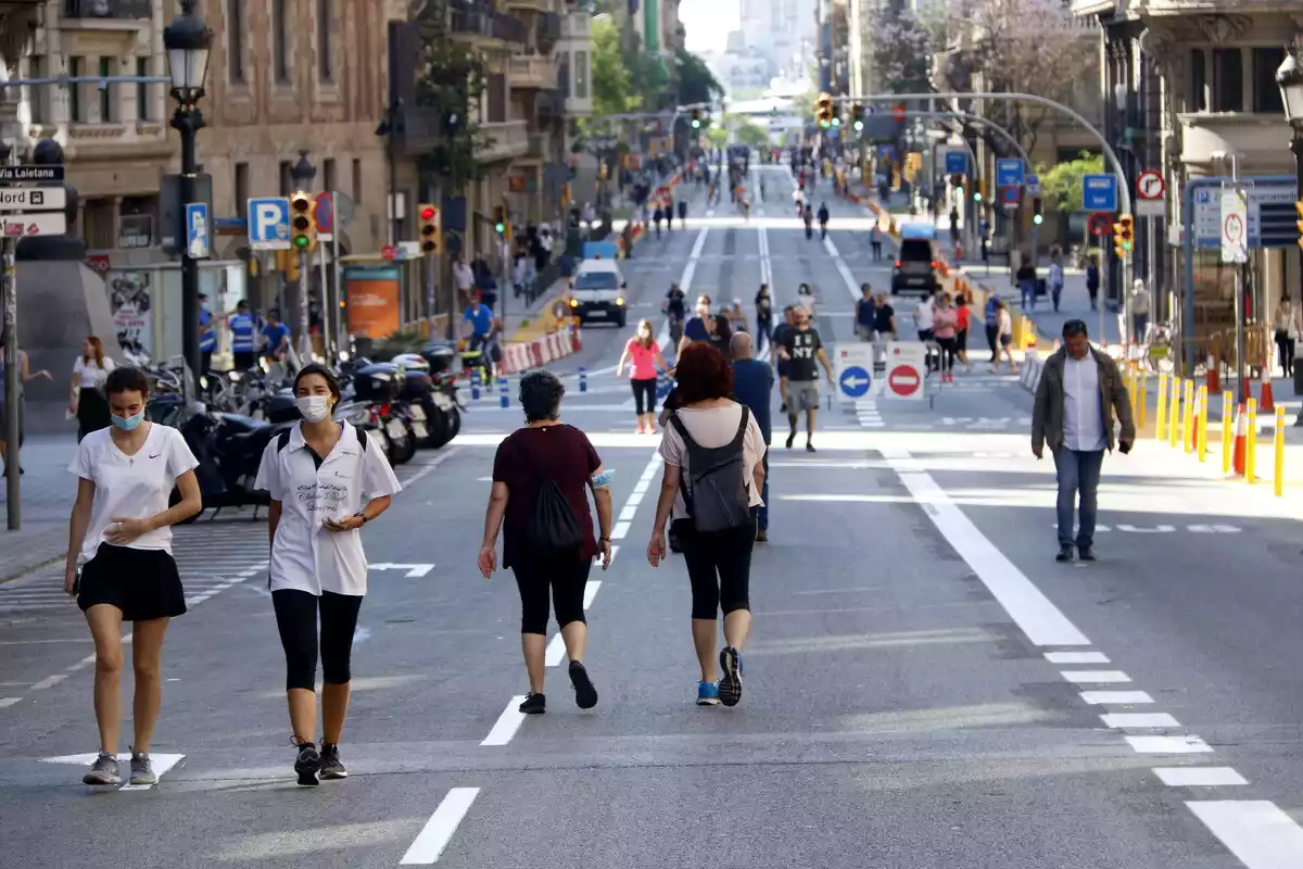 Ciutadans passejant per Via Laietana amb distància de seguretat pel coronavirus, tallada al trànsit, 23/05/2020