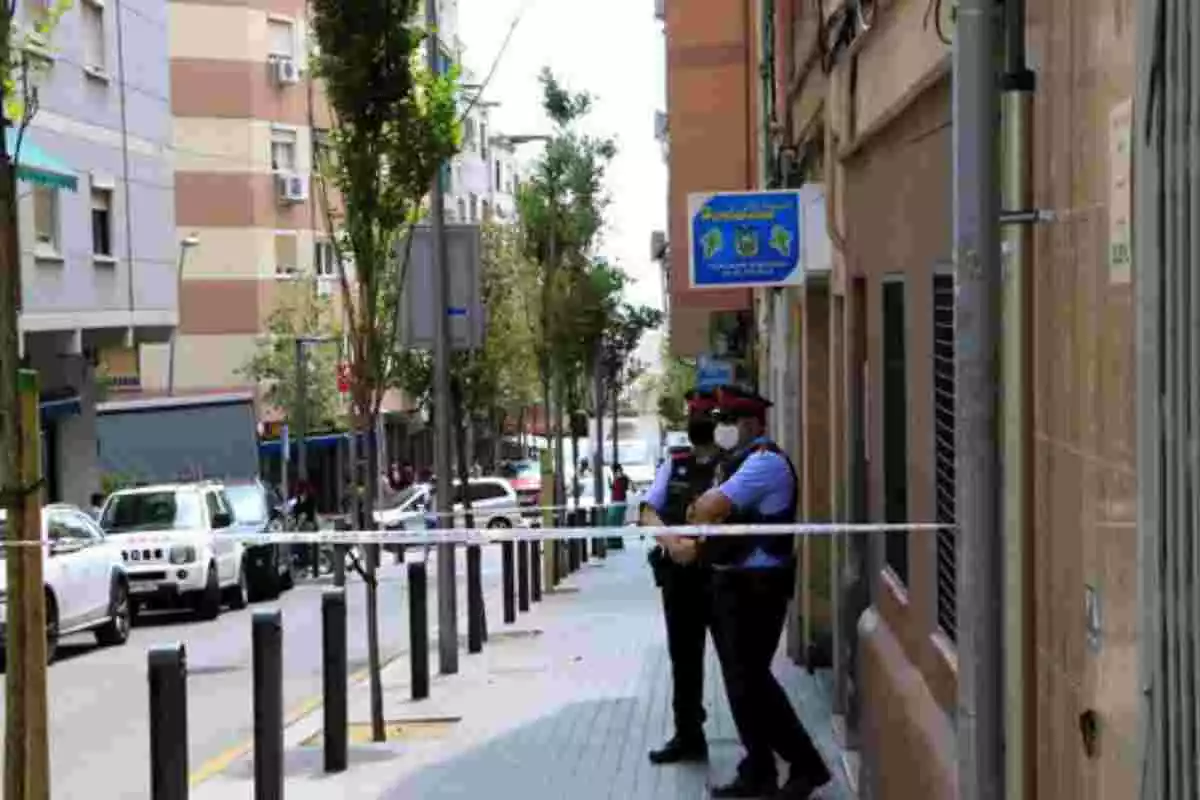 Dos agents dels Mossos d'Esquadra davant d'un edifici