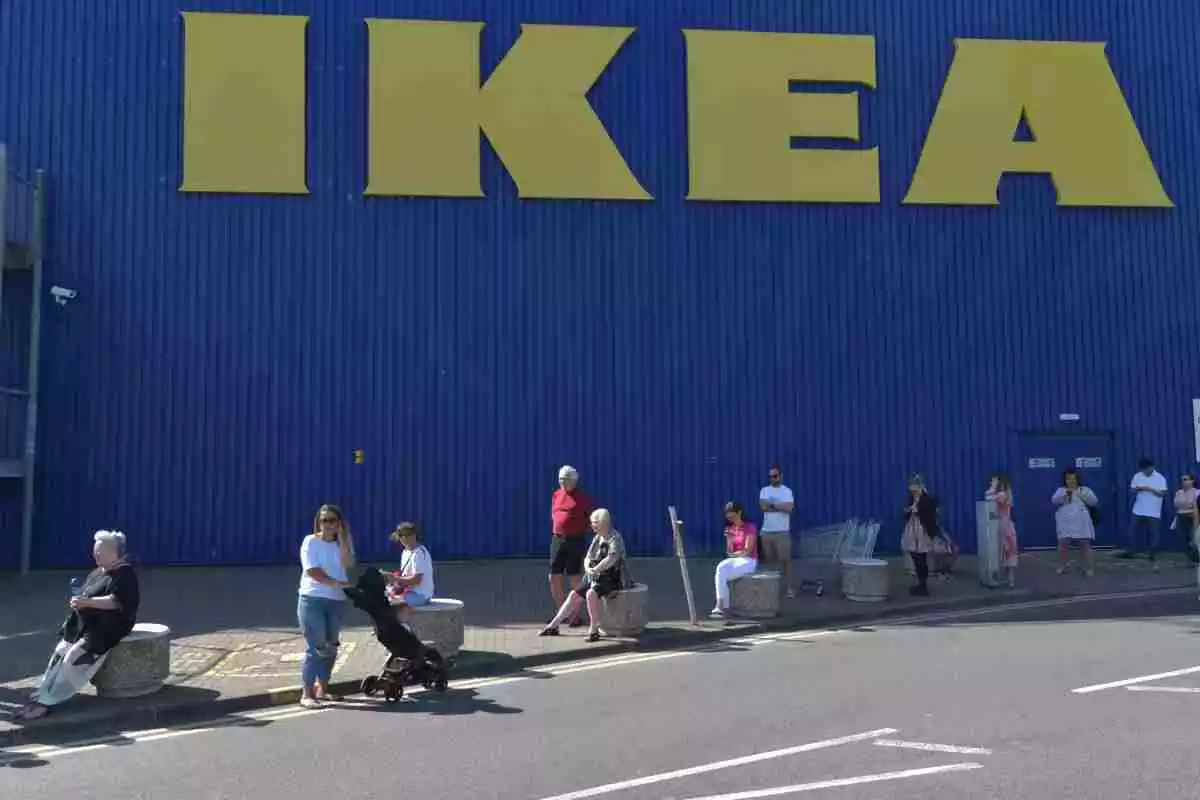 Diversos clients esperant per a poder accedir a una botiga IKEA amb les llestres grogues darrere