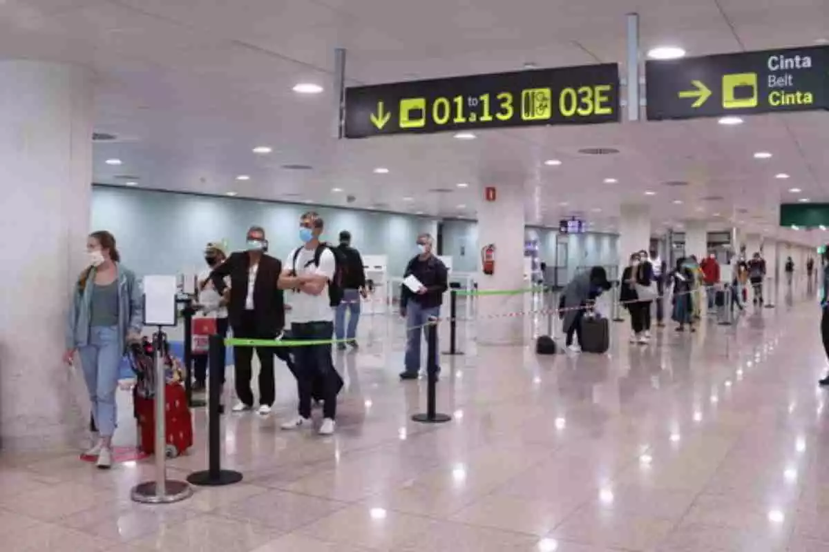 Diverses persones a l'Aeroport del Prat esperant per a poder embarcar