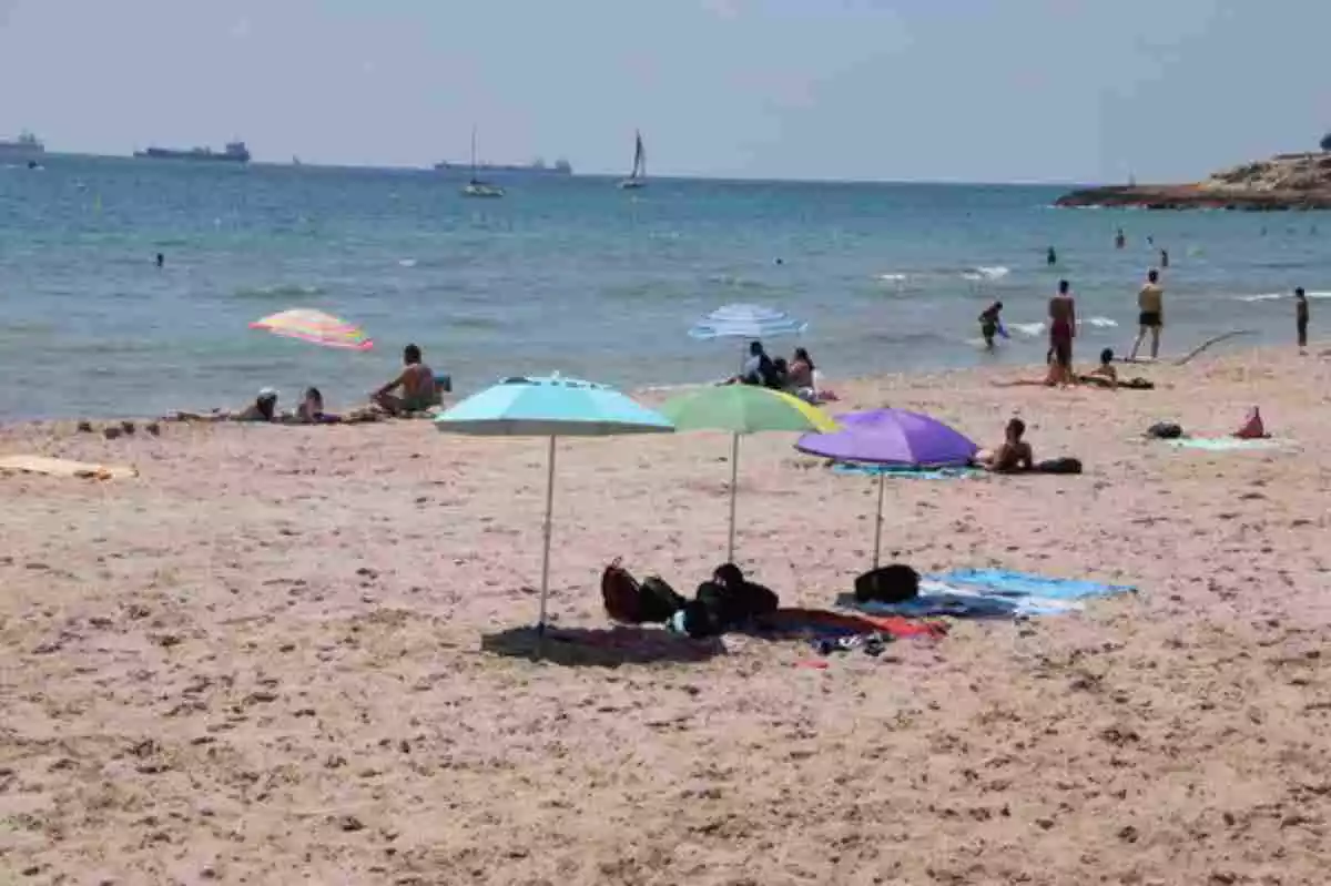 Diverses persones a la platja tarragonina de l'Arrabassada en els primers dies de desescalada