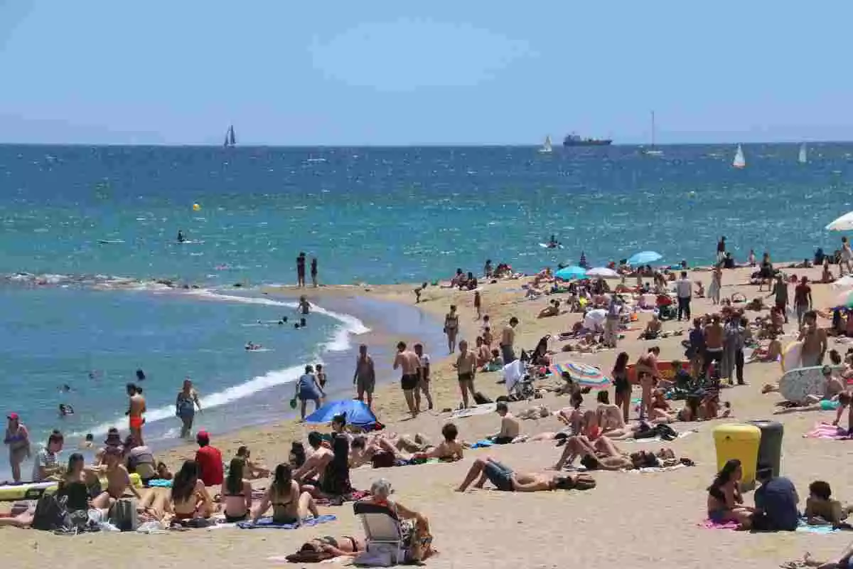 Imatge general de la platja de la Barceloneta amb un nombre visible de barcelonins gaudint del bon temps