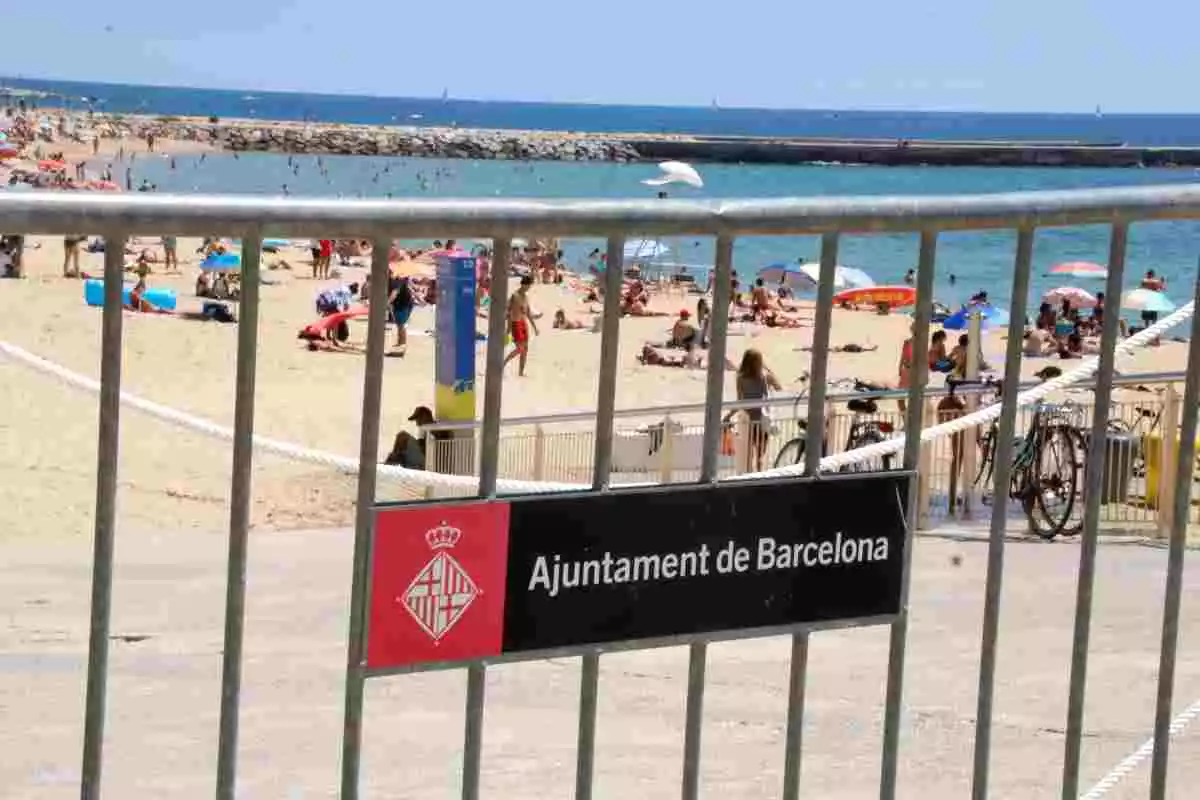 Pla obert de la platja Nova Icària de Barcelona amb una tanca en primer pla