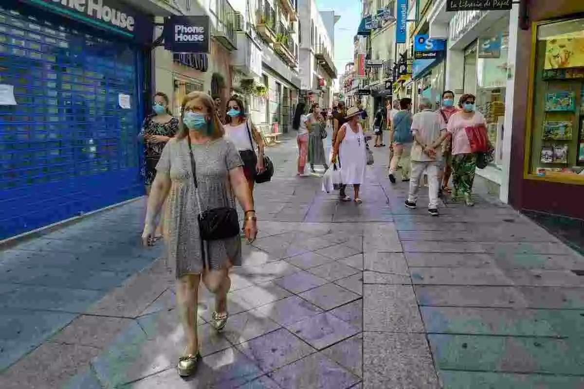 Persones caminant per un carrer d'Extremadura amb mascaretes