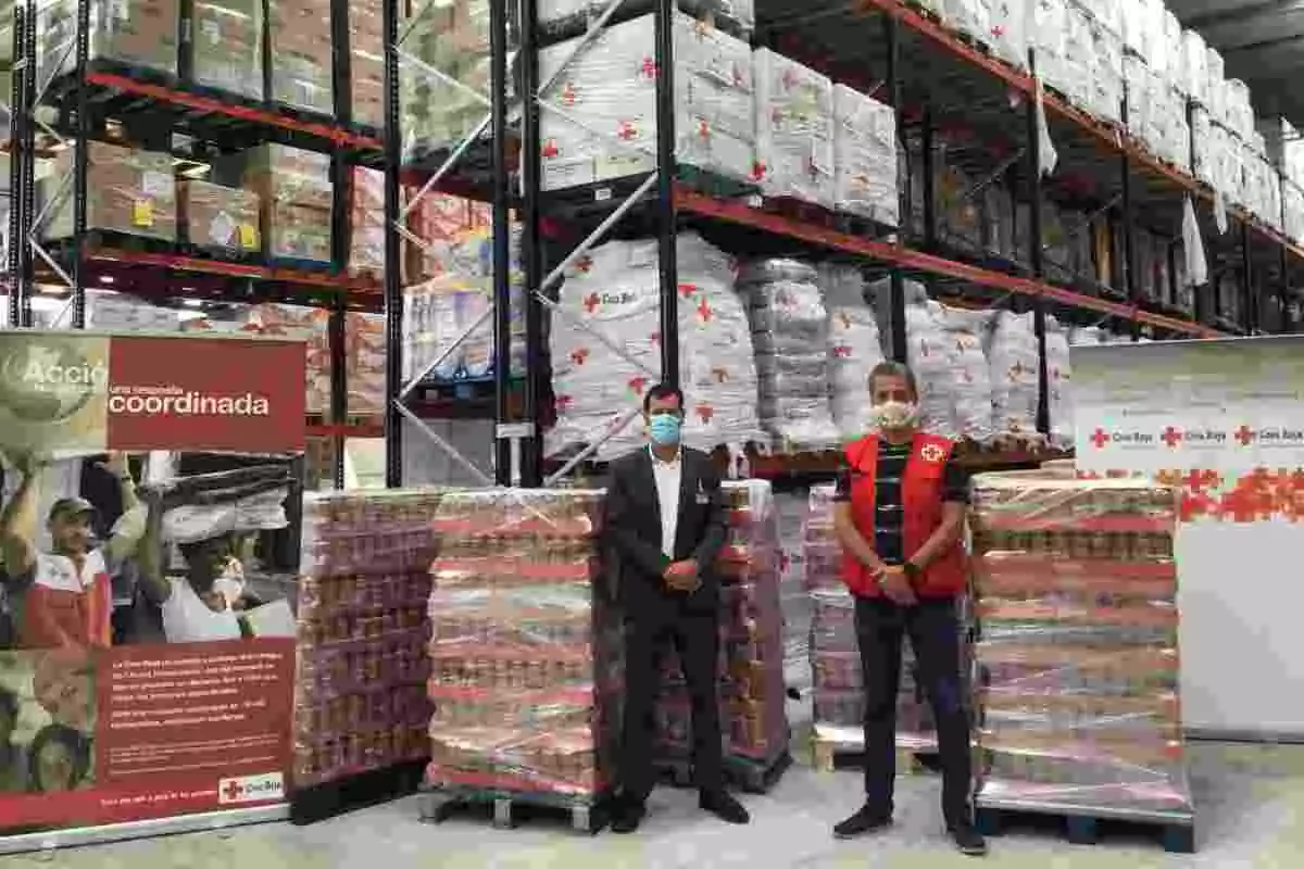 Imatge dels representants de Mercadona i la Creu Roja en el moment de la donació de les llenties cuites