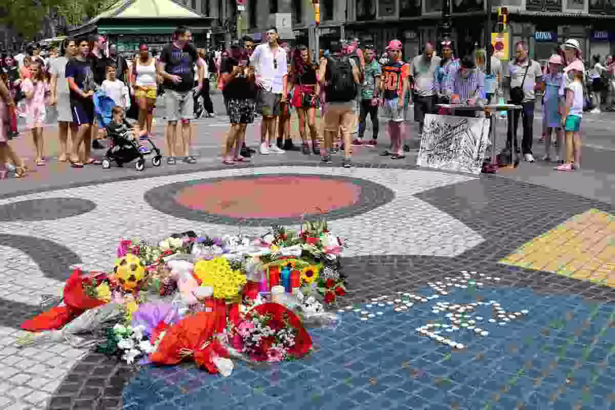Pla general del mosaic de Miró a la Rambla amb flors i espelmes en honor a les víctimes de l'atemptat del 17-A