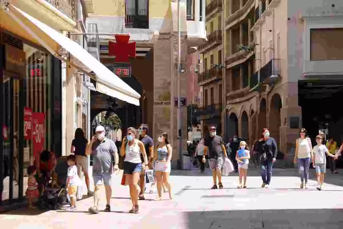 Diverses persones passejant amb mascareta per l'Eix Comercial de Lleida, a l'alçada de la plaça de la Paeria, el 5 de juliol de 2020