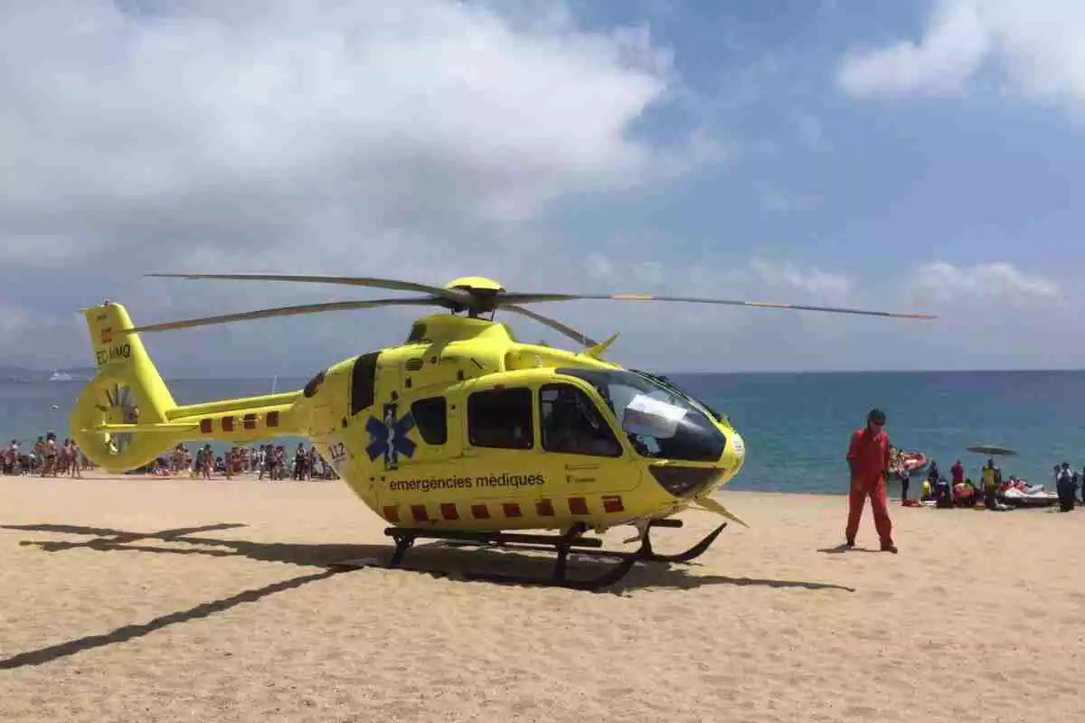 Equips d'emergència practicant maniobres de reanimació a una víctima amb l'helicòpter del SEM en primer terme