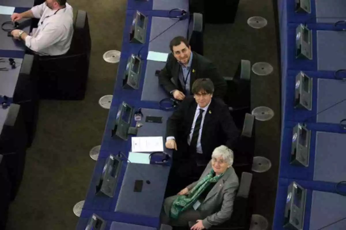 Carles Puigdemont, Clara Ponsatí i Toni Comín asseguts al Parlament Europeu mirant a dalt
