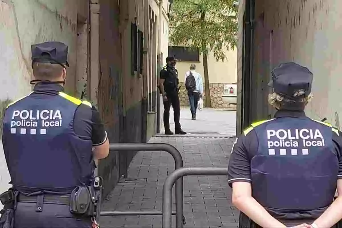 Dos agents de la Policia Local de la Jonquera vigilant un pis al carrer Major