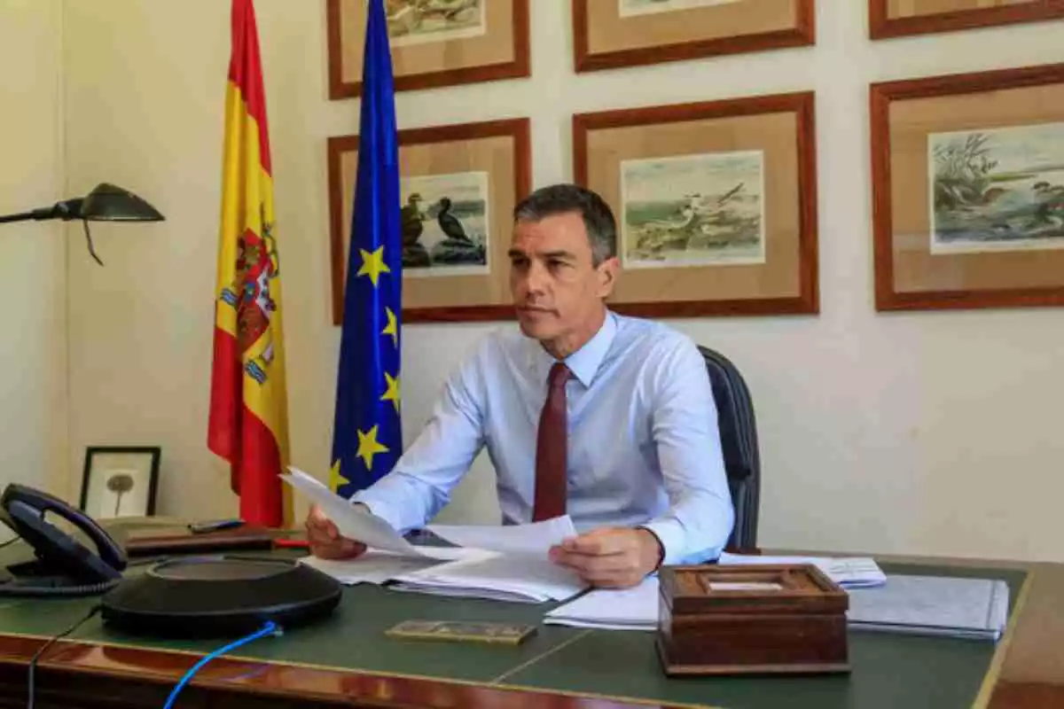 El president Pedro Sánchez amb camisa al seu despatx de la Moncloa amb les banderes espanyola i europea
