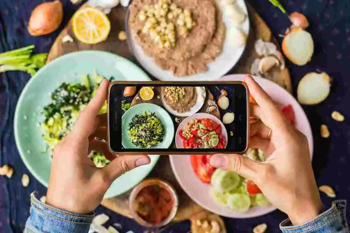 Una persona fent una foto a menjar amb un mòbil