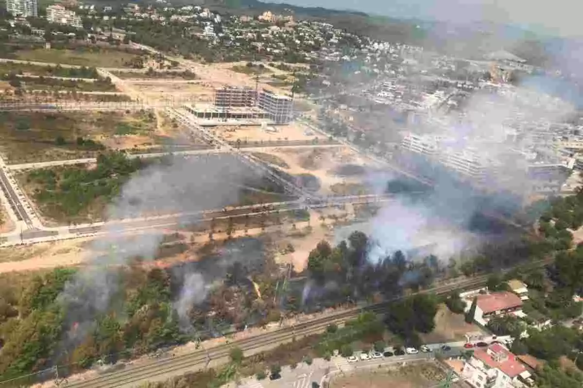 Imatge del fum provocat per un incendi a tocar de les vies de tren a Sitges