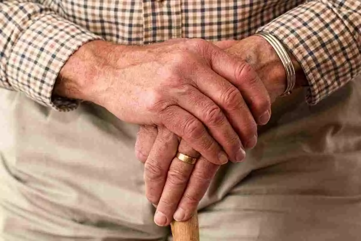 Les mans d'un home gran mentre agafa un bastó
