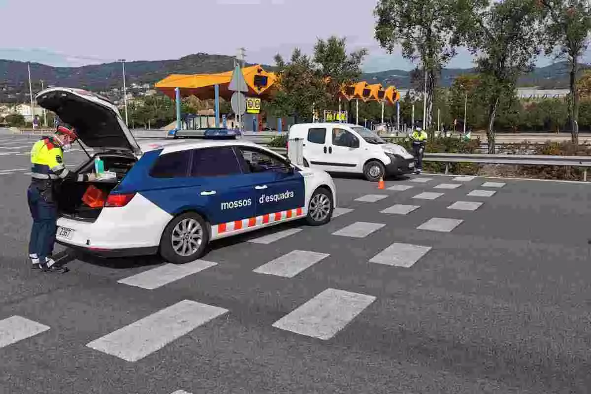 Un control dels Mossos d'Esquadra amb dos agents, un dels quals al costat del cotxe policial