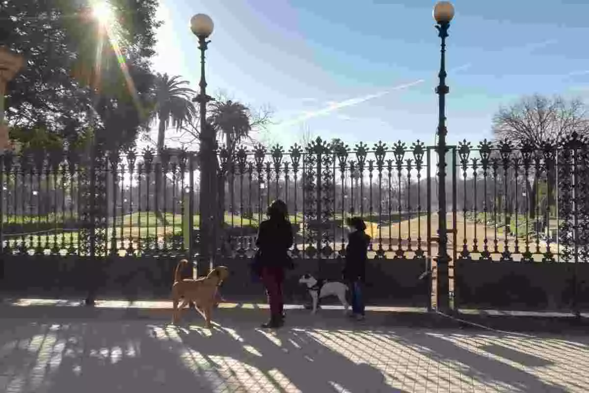 Un dels accessos al parc de la Ciutadella de Barcelona amb dues persones passejant gossos davant