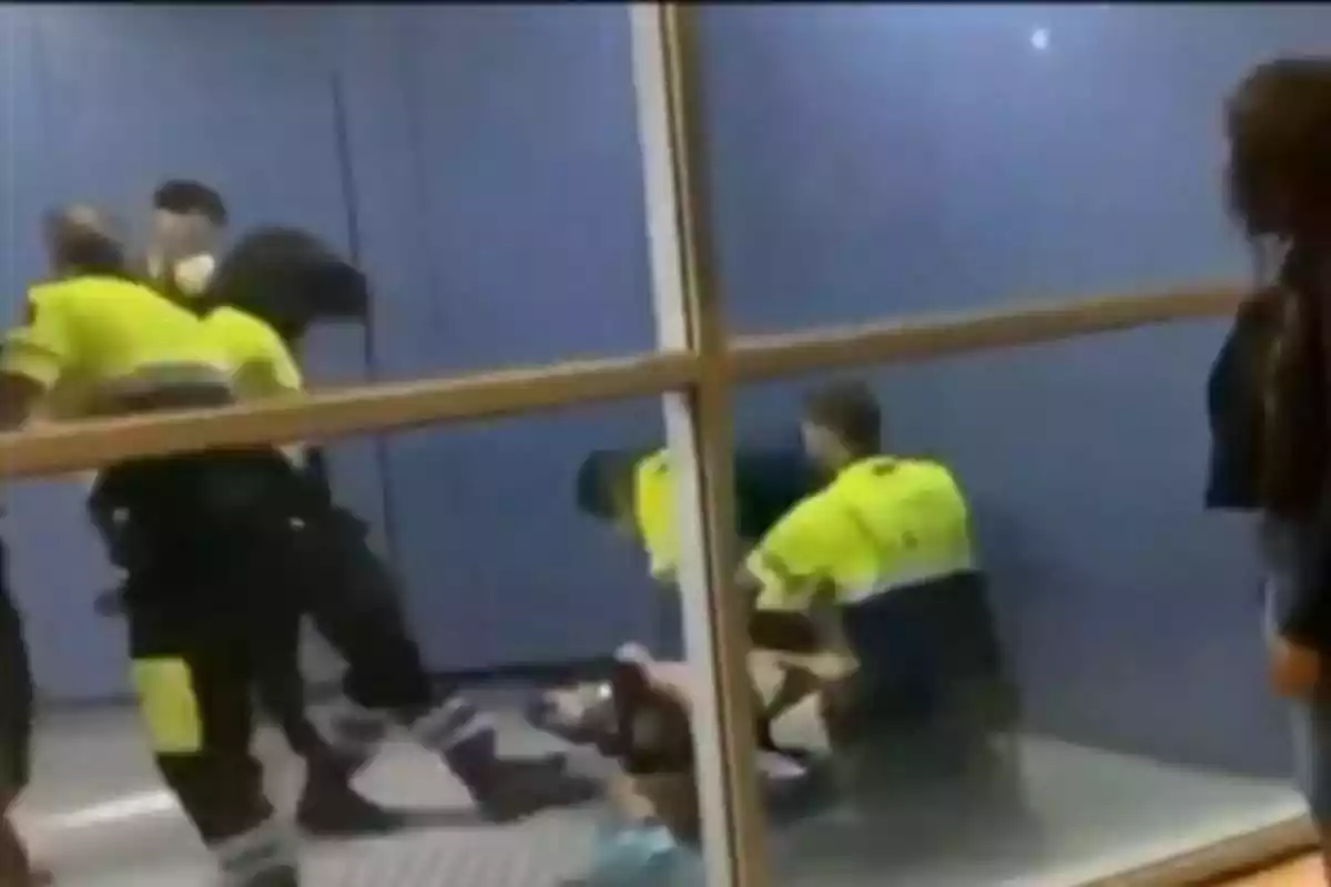 Fotograma del vídeo en què es veuen diversos vigilants de seguretats immobilitzant el viatger