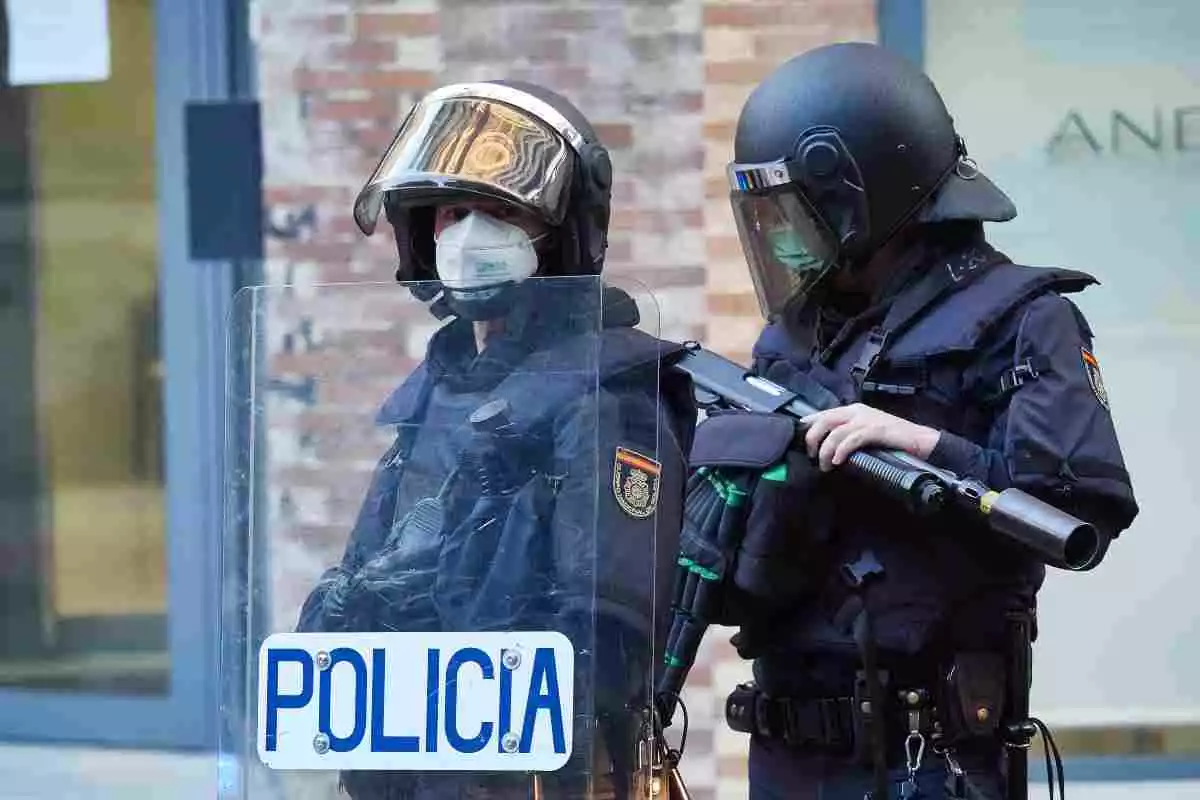 Imatge d'arxiu de dos agents antidisturbis de la Policia Nacional, protegits amb casc i escut