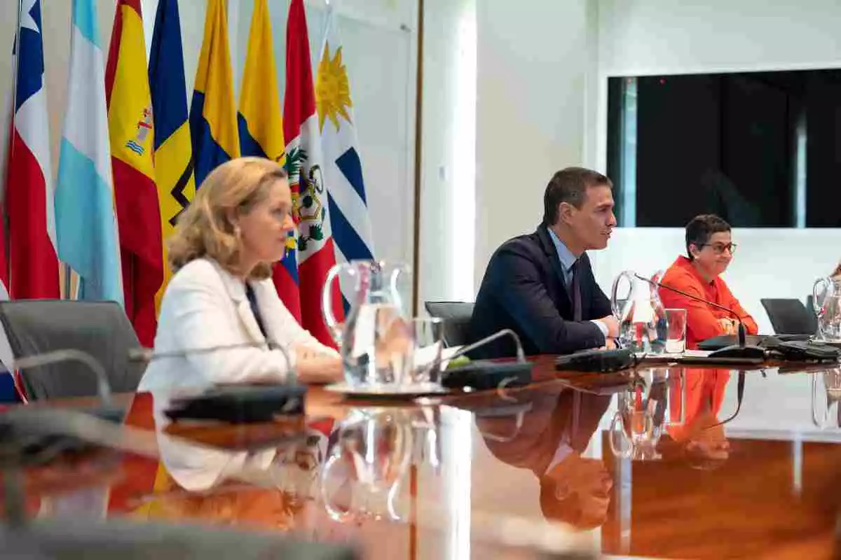 Imatge de Nadia Calviño, a l'esquerra, i Pedro Sánchez, al centre, durant una conferència telemàtica