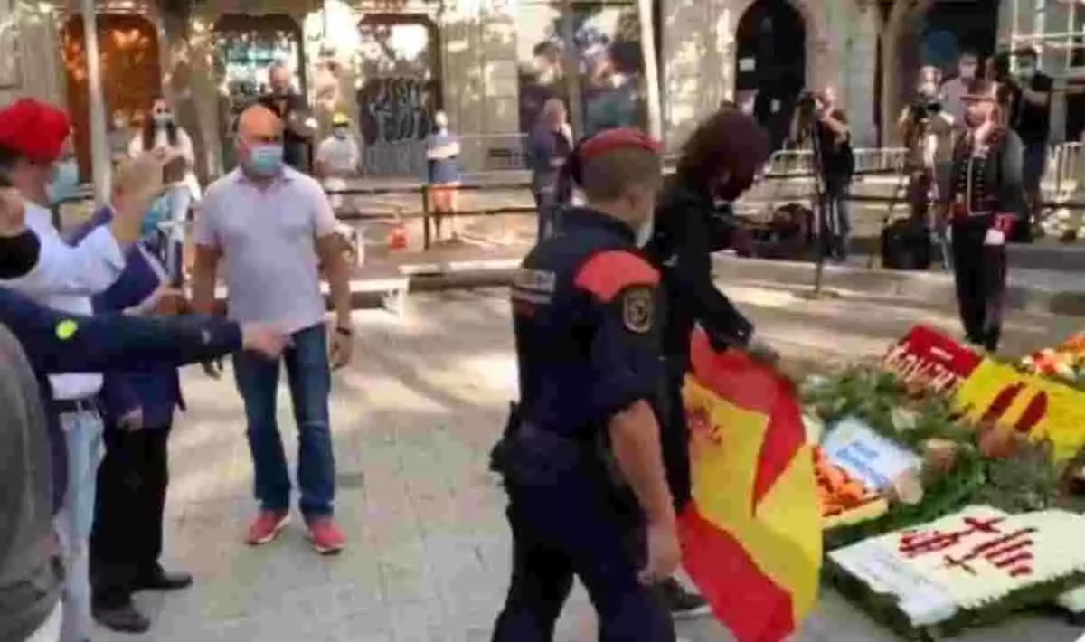 Imatge del periodista Cake Minuesa col·locant una bandera d'Espanya en l'ofrena floral a l’estàtua de Rafel de Casanova