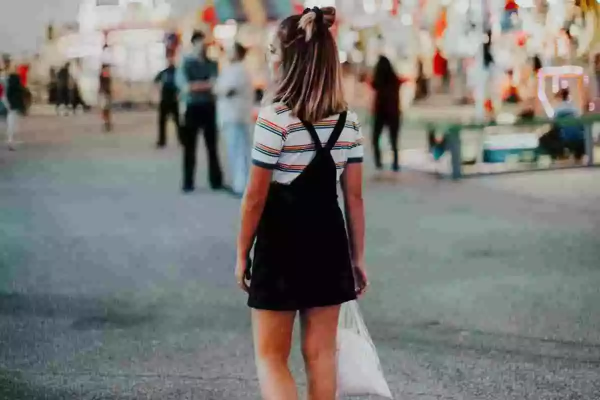 Imatge d'una noia d'esquenes ubicada en un carrer