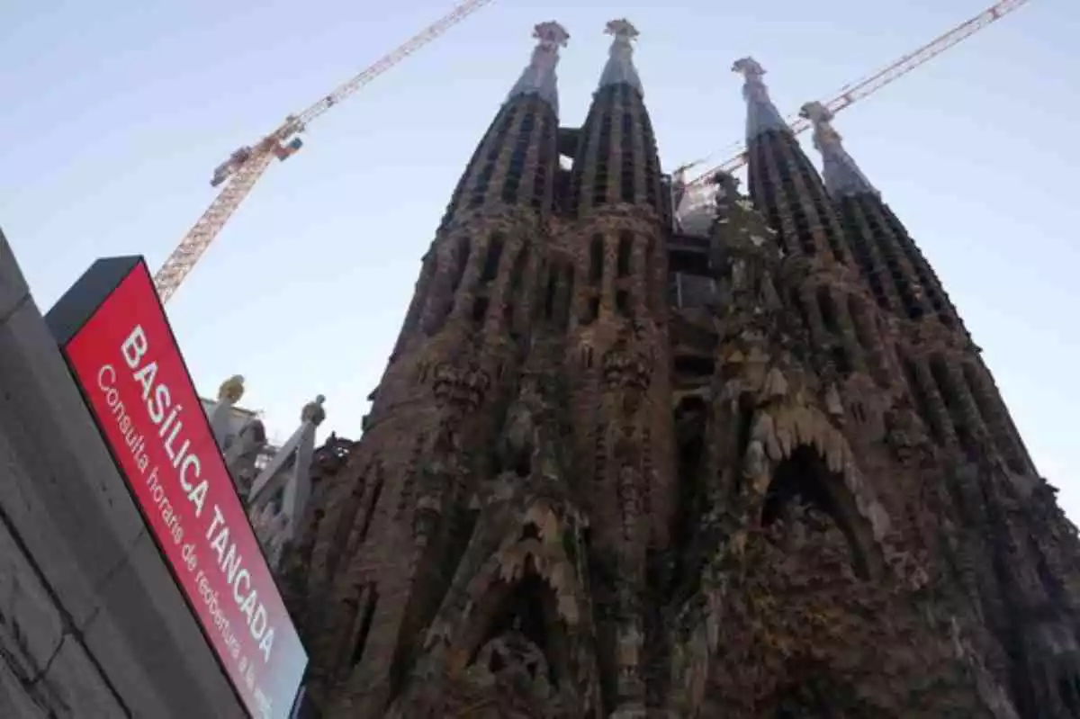 La Basílica de la Sagrada Família amb les obres de construcció i un cartell anunciant que està tancada