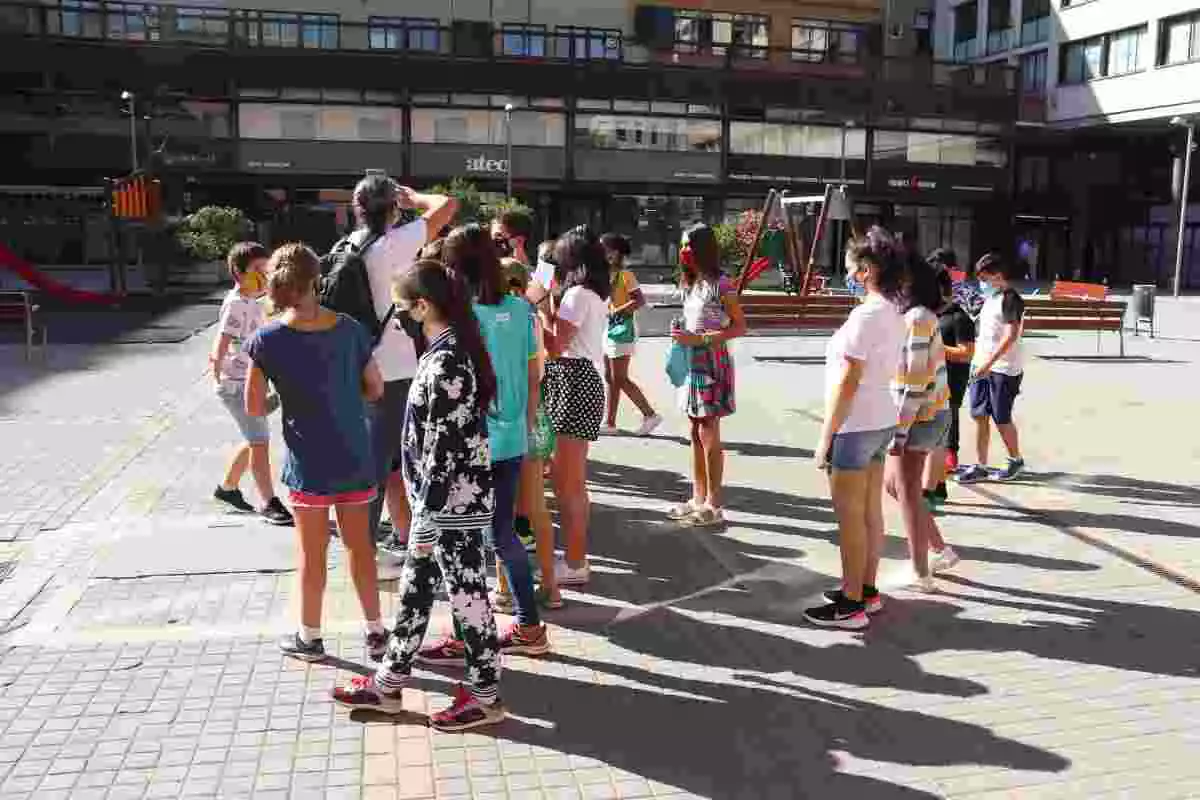 Pla obert d'un grup d'alumnes de l'escola Eiximenis arribant a la plaça de Josep Pla de Girona