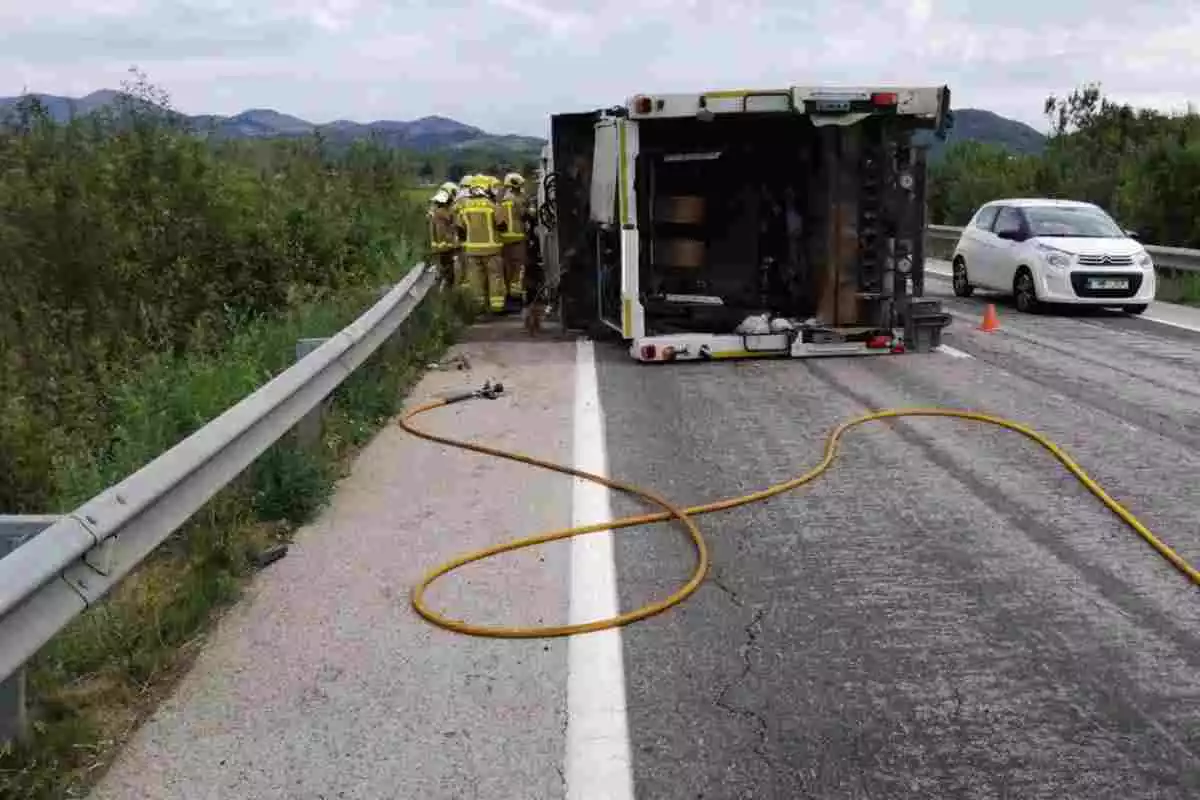 Un vehicle accidentat i bolcat amb diversos efectius dels Bombers al costat