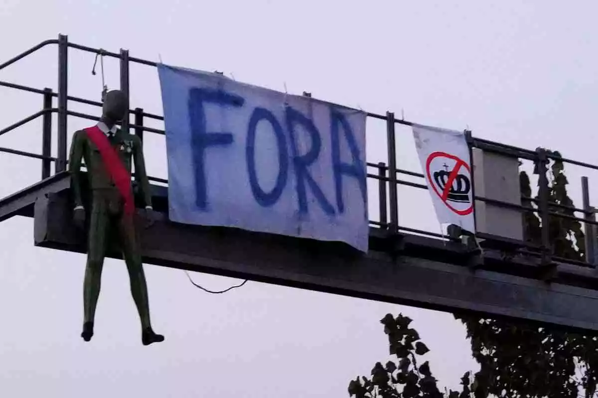 El maniquí que representa Felip VI amb els dos cartells en contra del rei penjant aquest 9 d'octubre del 2020 al matí del radar de tram a Cassà de la Selva