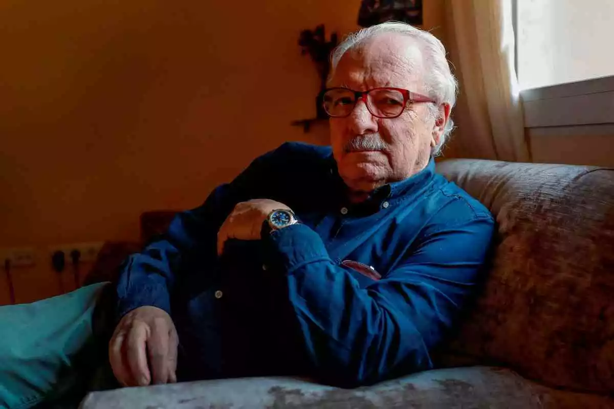 Javier Reverte, en una imatge d'arxiu a casa seva, assegut al sofà