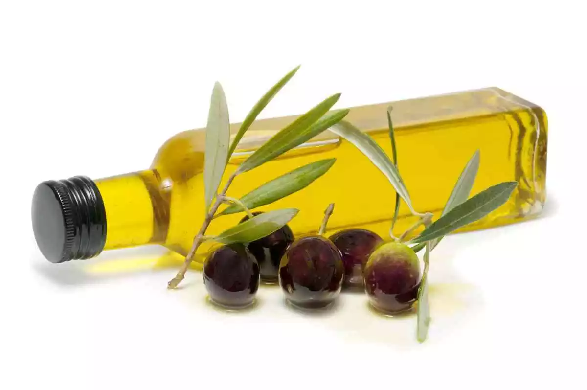 Muntatge d'una ampolla d'oli amb unes olives en primer pla