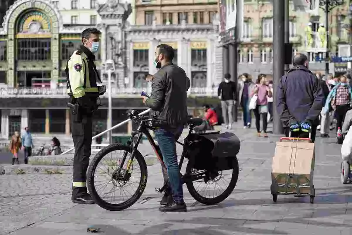 Un policia i una home en bicicleta parlen en un cèntric carrer de Bilbao