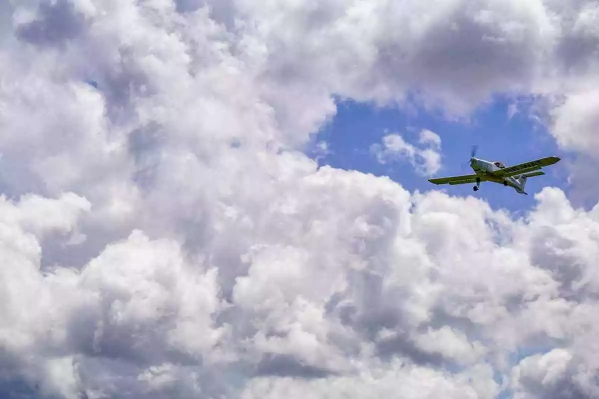 Una avioneta volant entre els núvols