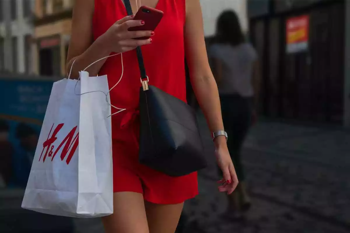 Una noia passejant amb una bossa d'H&M